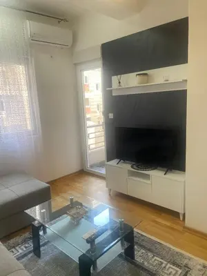 a living room with a couch and a glass table at Modern 1BR Apartment in Ljubović Podgorica in Podgorica