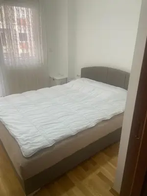 a white bed in a room with a window at Modern 1BR Apartment in Ljubović Podgorica in Podgorica