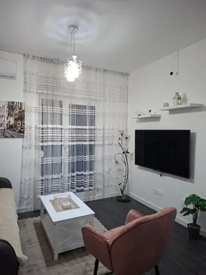 a living room with a flat screen tv and a couch at Apartman Asia in Podgorica