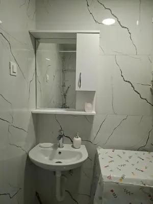 a white bathroom with a sink and a mirror at Apartman Asia in Podgorica
