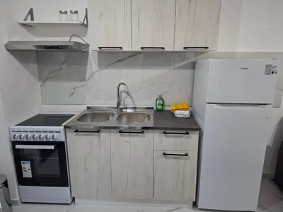 a kitchen with a sink and a white refrigerator at Apartman Asia in Podgorica