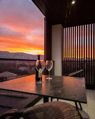 a table with two wine glasses on a balcony with a sunset at Luxury Villa Bar in Bar