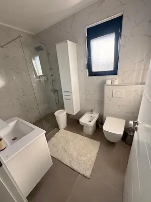 a white bathroom with a sink and a toilet at Luxury Villa Bar in Bar