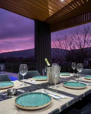 a table with plates and wine glasses on top of it at Luxury Villa Bar in Bar
