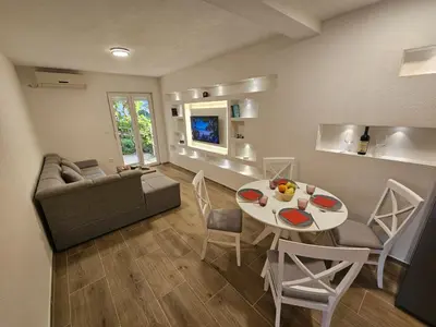 a living room with a couch and a table at Apartment Under the Palm Tree in Budva