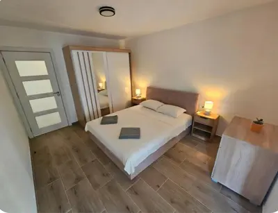 a bedroom with a white bed and a large mirror at Apartment Under the Palm Tree in Budva