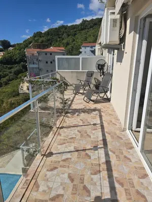 a balcony of a house with two chairs on it at Exclusive penthouse with stunning panoramic views in Prijevor