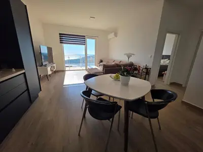 a living room with a white table and chairs at Exclusive penthouse with stunning panoramic views in Prijevor