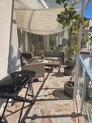a patio with a couch and a table on a patio at Exclusive penthouse with stunning panoramic views in Prijevor