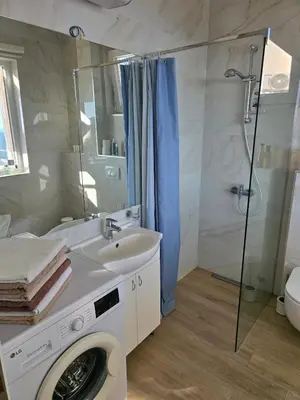 a bathroom with a sink and a washing machine at Exclusive penthouse with stunning panoramic views in Prijevor