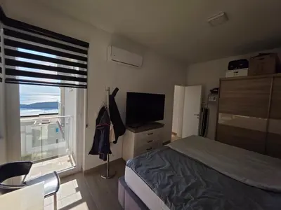 a bedroom with a bed and a television and a window at Exclusive penthouse with stunning panoramic views in Prijevor