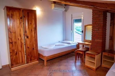 a small bedroom with a bed and a mirror at Beach House Noki 1 in Ulcinj