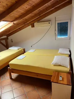 two twin beds in a room with a window at Beach House Noki 1 in Ulcinj