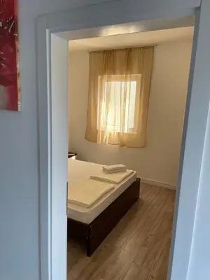 a small bedroom with a bed and a window at Lupo in Budva