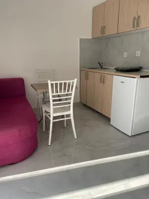 a kitchen with a chair and a table and a refrigerator at Apartment Lupo in Budva