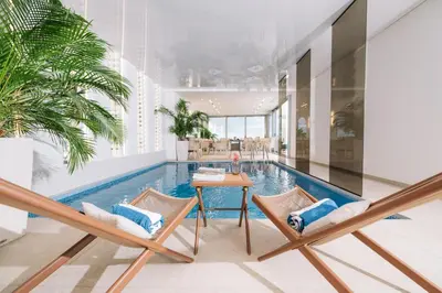 a living room with a pool and two chairs and a table at Hotel Senator Lux in Ulcinj