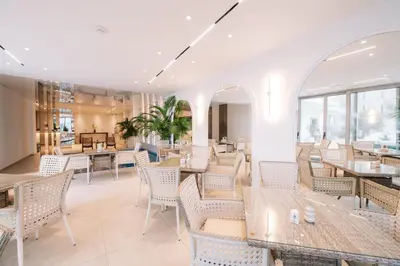 a restaurant with tables and chairs and windows at Hotel Senator Lux in Ulcinj