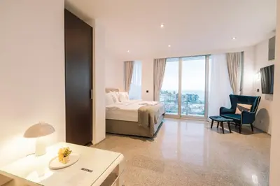 a hotel room with a bed and a chair at Hotel Senator Lux in Ulcinj