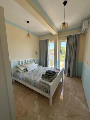 a bedroom with a bed and a large window at Ulcinj Bay Apartmant in Ulcinj