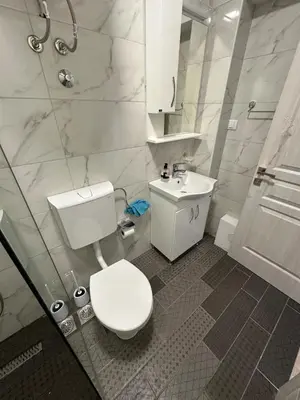 a white bathroom with a toilet and a sink at Ulcinj Bay Apartmant in Ulcinj