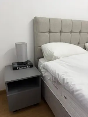 a bed with a lamp on a night stand next to it at Premium Suites with GARAGE in Podgorica