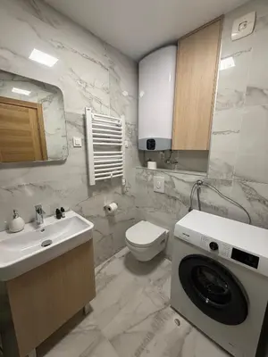 a bathroom with a sink and a washing machine at Premium Suites with GARAGE in Podgorica