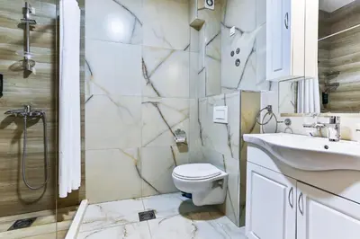 a bathroom with a toilet and a sink and a shower at Hotel Hoti 2 Wellnes & Spa in Ulcinj