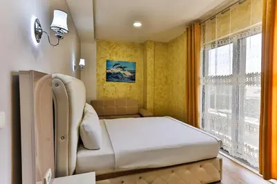 a bedroom with a bed and a couch and a window at Hotel Hoti 2 Wellnes & Spa in Ulcinj