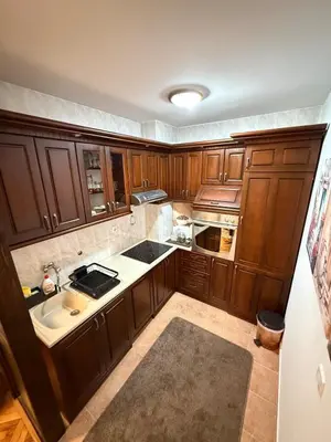a large kitchen with wooden cabinets and a sink at Sunčana oaza, Sutomore in Sutomore
