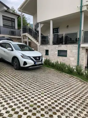 a white car parked in front of a house at Villa Andrea Lower Level in Kavač