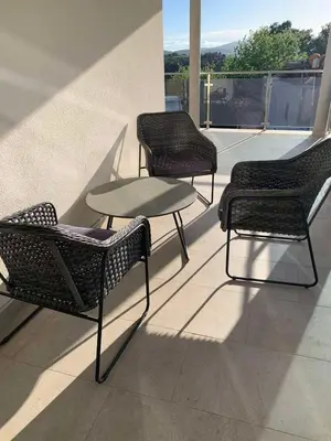 a group of chairs and a table on a balcony at Villa Andrea Lower Level in Kavač