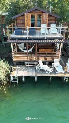 a cabin on the water with chairs on a dock at Ada Bojana River House 1 in Ulcinj