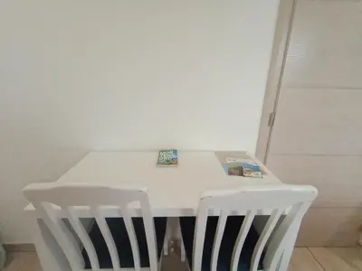 a white table with two white chairs in a room at Montebay Studio in Dobra Voda