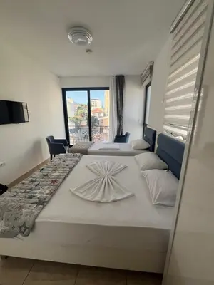 two beds in a room with a large window at Montebay Studio in Dobra Voda