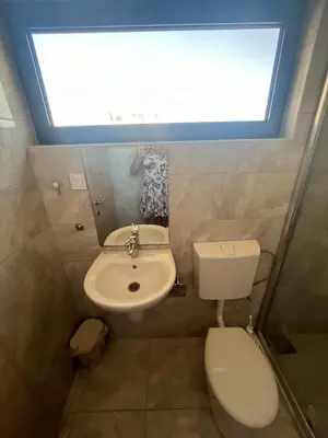 a bathroom with a toilet and a sink and a window at Montebay Studio in Dobra Voda