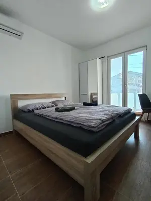 a bedroom with a large bed with a large window at Martins Apartments in Dobra Voda