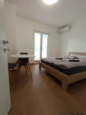 a white room with a bed and a table at Martins Apartments in Dobra Voda