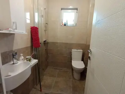 a bathroom with a white toilet and a sink at Martins Apartments in Dobra Voda