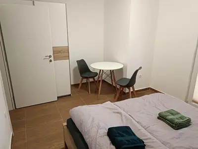 a bedroom with a bed and a table and chairs at Martins Apartments in Dobra Voda