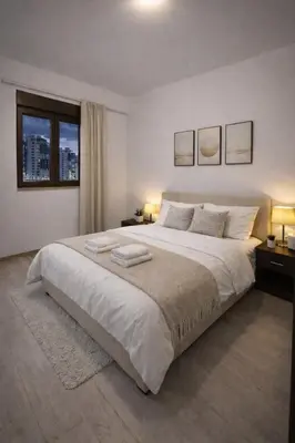 a bedroom with a large white bed with two lamps at Modern Apartment Near the Beach - Budva in Budva