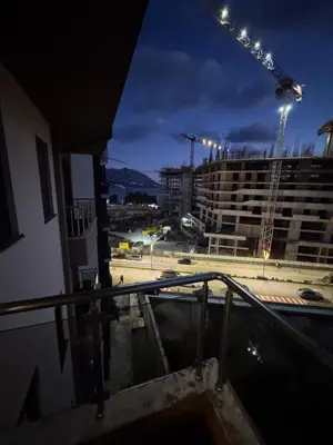 a view from the balcony of a building with a crane at Modern Apartment Near the Beach - Budva in Budva