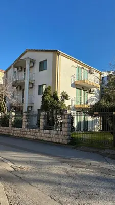 a building with a fence in front of a building at Apart Ludmila in Becici
