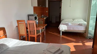 a room with a bed and a table and chairs at Apart Ludmila in Becici
