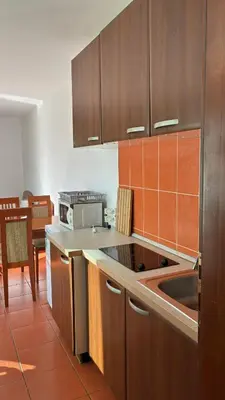 a kitchen with wooden cabinets and a counter top at Apart Ludmila in Becici