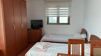 a small room with two beds and a television at Apart Ludmila in Becici