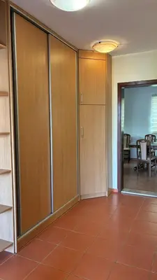 an empty room with wooden cabinets and a dining room at Apart Ludmila in Becici