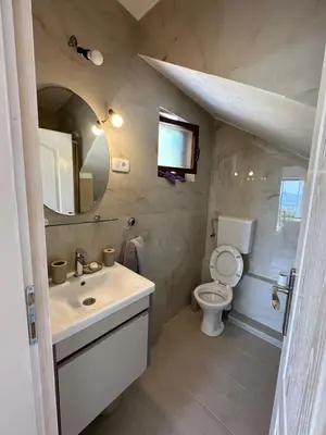 a bathroom with a sink and a toilet and a mirror at Studio KIKA in Tivat