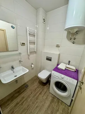 a bathroom with a washing machine and a sink at Modern City Apartment in Podgorica