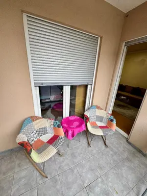two chairs and a table in front of a window at Modern City Apartment in Podgorica