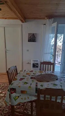a dining room with a table with a tablecloth with birds on it at Apartmani Primorski hrast in Bar